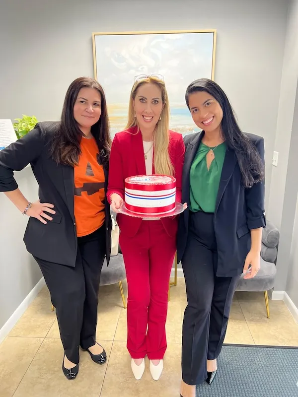 Team celebrating a successful immigration case with an American flag cake