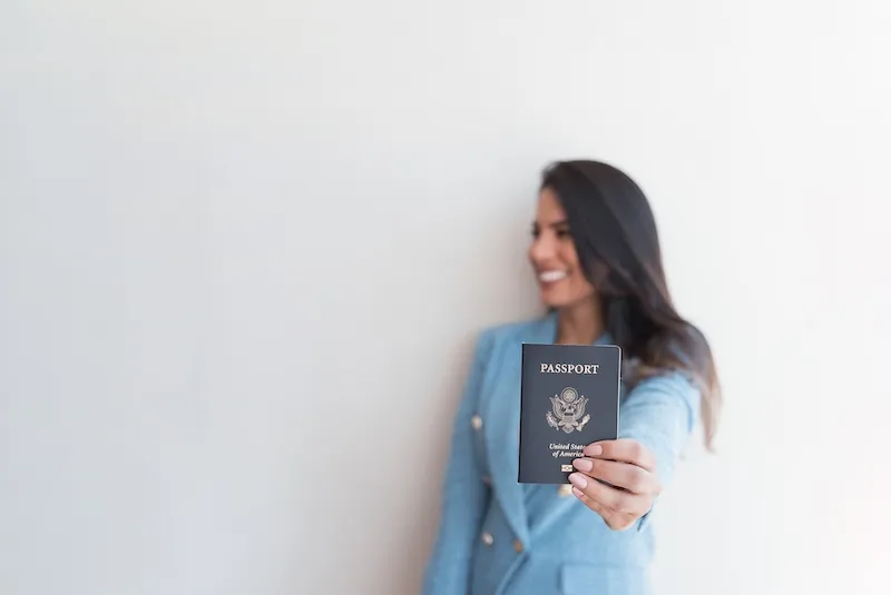 Isis Alpoim Scardua smiling and holding up a United States passport
